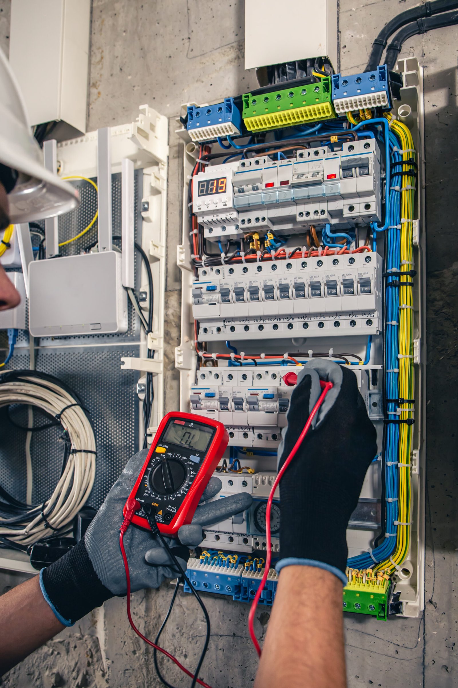 Man, an electrical technician working in a switchboard with fuses.